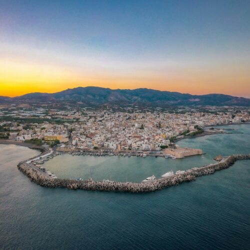 Breathtaking aerial shot of Ierapetra harbor and cityscape during the sunset in Greece.
