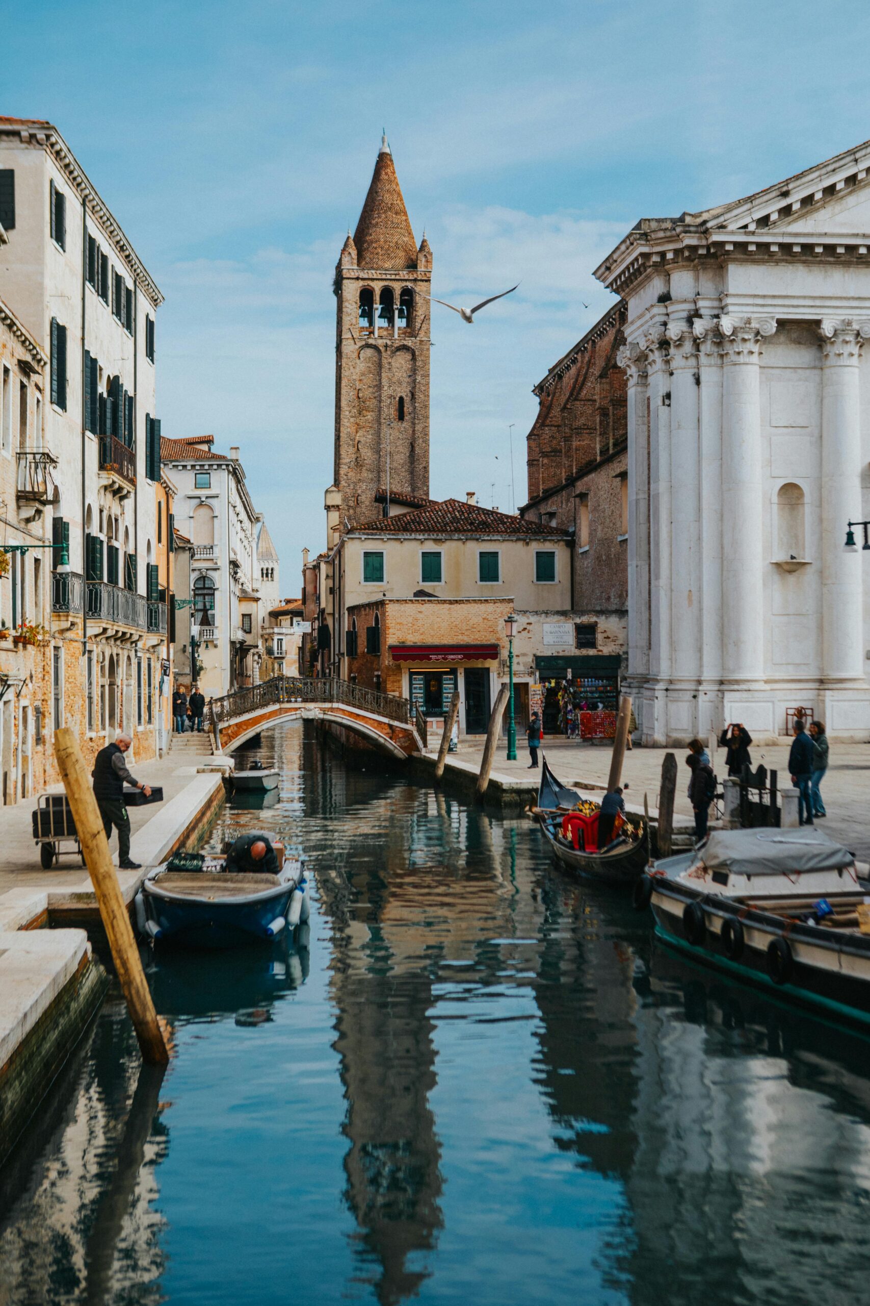 Picturesque view of a Venetian canal with historical architecture and boats during the day.