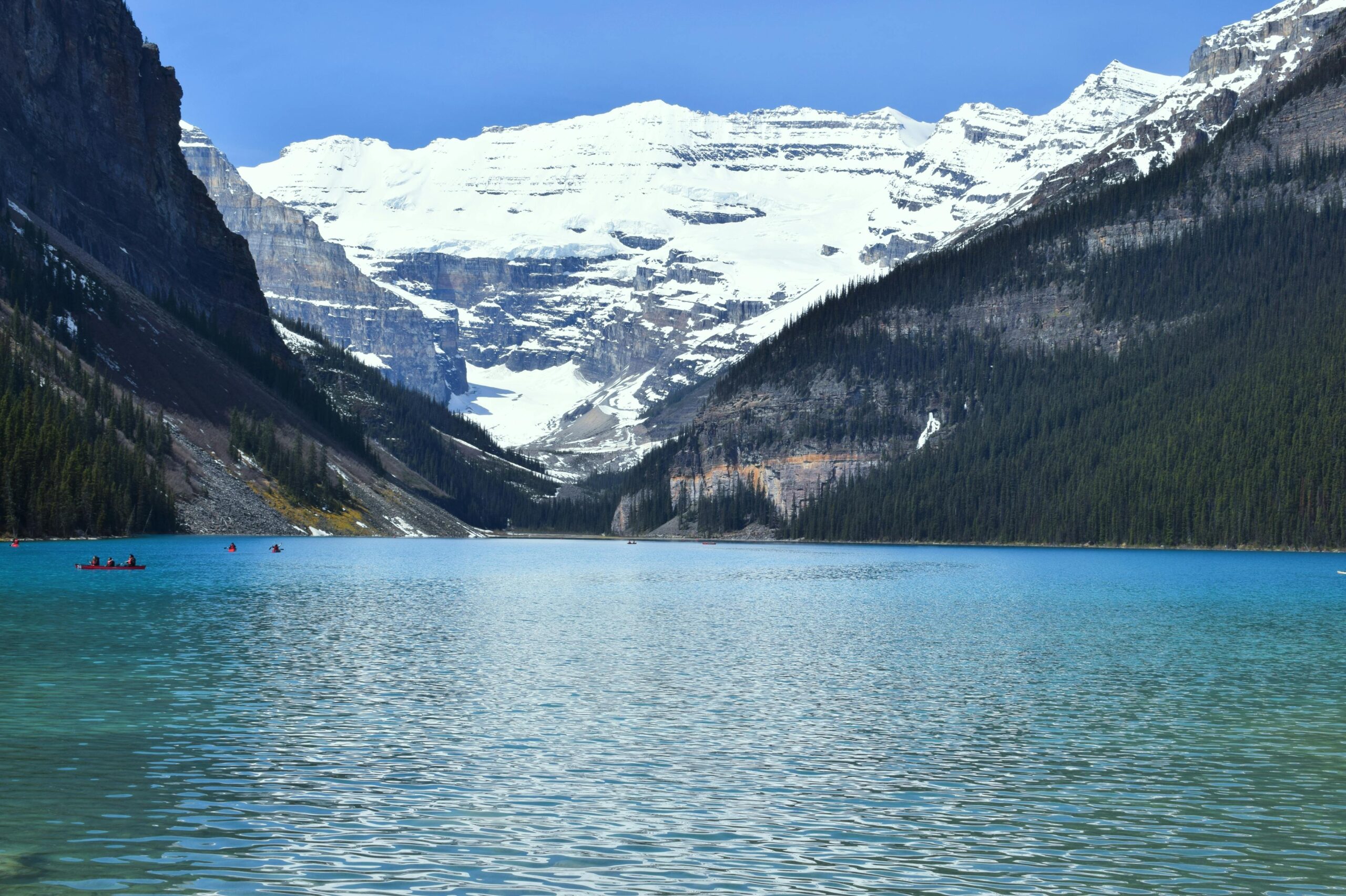 Breathtaking view of Lake Louise's blue water and snowy peaks. A must-visit in Canadian Rockies.