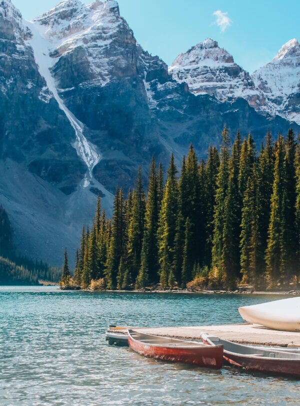 Beautiful lakeside scene with canoes and snow capped mountains in Banff National Park.