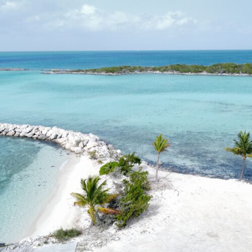 Stunning aerial shot of a tropical beach with pristine white sand and vivid turquoise waters, perfect for a serene getaway.